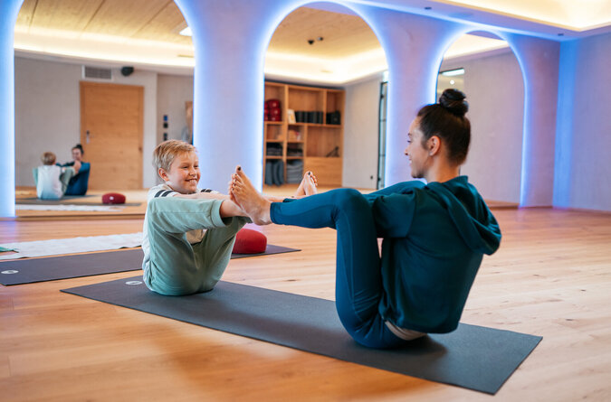 Mutter und Sohn machen zusammen Yoga in einem familienfreundlichen Hotel.
