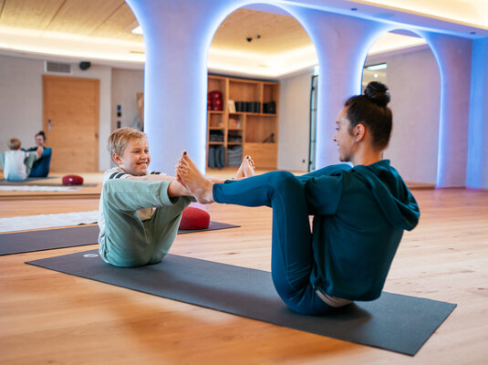 Mutter und Sohn machen zusammen Yoga in einem familienfreundlichen Hotel.