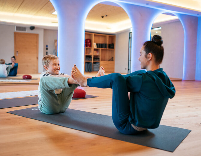 Mutter und Sohn machen zusammen Yoga in einem familienfreundlichen Hotel.